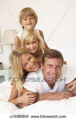 Portrait Of Young Family Relaxing In Bed Together View Large Photo Image Picture - Portrait Of Young Family Relaxing In Bed Together. Fotosearch