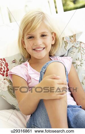 Stock Image - Portrait Of Young Girl Relaxing On Sofa. Fotosearch