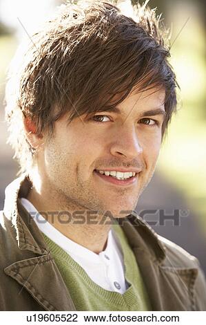 Stock Image - Portrait Of Young Man In Autumn Park. Fotosearch