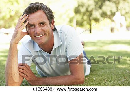Stock Photo - Portrait Of Young Man In Park. Fotosearch