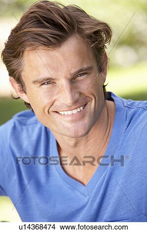 Portrait Of Young Man Relaxing In Park View Large Photo Image Picture - Portrait Of Young Man Relaxing In Park. Fotosearch