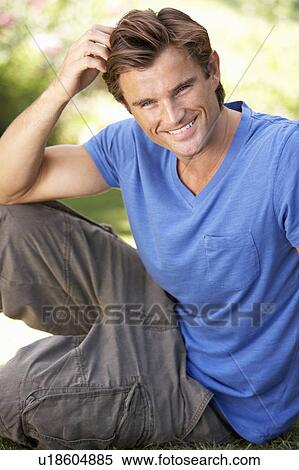 Stock Photography - Portrait Of Young Man Relaxing In Park. Fotosearch