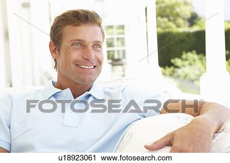 Portrait Of Young Man Relaxing On Sofa View Large Photo Image Stock Image - Portrait Of Young Man Relaxing On Sofa. Fotosearch