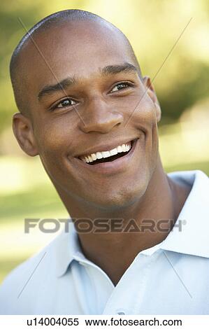 Stock Photography - Portrait Of Young Man Sitting In Park. Fotosearch