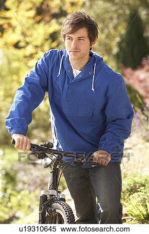 Portrait Of Young Man With Cycle In Autumn Park View Large Photo Image Stock Photography - Portrait Of Young Man With Cycle In Autumn Park. Fotosearch
