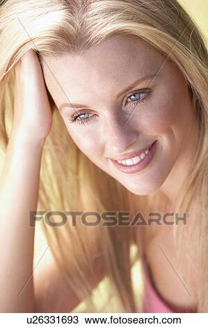 Stock Image - Portrait Of Young Woman Relaxing In Park. Fotosearch