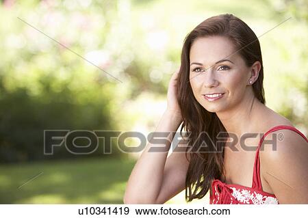 Stock Photo - Portrait Of Young Woman Relaxing In Park. Fotosearch