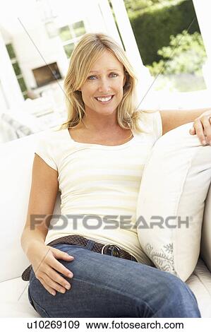 Stock Photo - Portrait Of Young Woman Relaxing On Sofa. Fotosearch