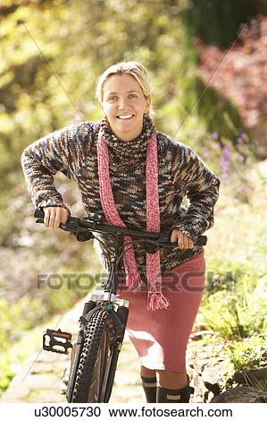 Portrait Of Young Woman With Cycle In Autumn Park View Large Photo Image Stock Image - Portrait Of Young Woman With Cycle In Autumn Park. Fotosearch