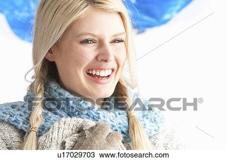 Stock Image - Pretty Young Woman Wearing Warm Winter Clothes In Studio. Fotosearch