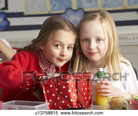 Stock Photography - Primary School Pupils Enjoying Packed Lunch In Classroom. Fotosearch