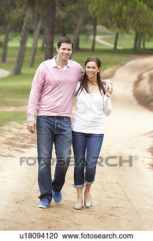 Romantic couple enjoying walk in park View Large Photo Image Stock Image - Romantic couple enjoying walk in park. Fotosearch