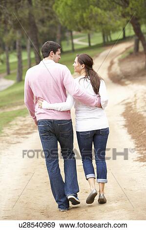 Romantic couple enjoying walk in park View Large Photo Image Stock Photo - Romantic couple enjoying walk in park. Fotosearch