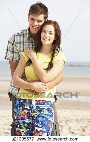 Stock Photo - Romantic Teenage Couple Embracing On Beach . Fotosearch