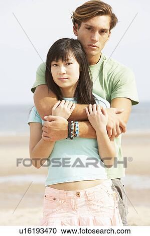 Stock Image - Romantic Young Couple Embracing On Beach . Fotosearch