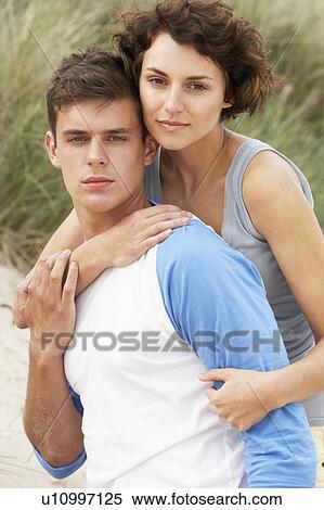 Stock Photography - Romantic Young Couple Embracing On Beach . Fotosearch