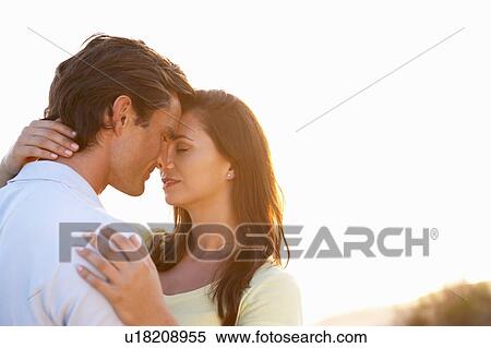 Stock Photography - Romantic Young couple in love at sunset. Fotosearch