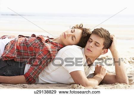 Romantic Young Couple Relaxing On Beach View Large Photo Image Stock Photo - Romantic Young Couple Relaxing On Beach. Fotosearch