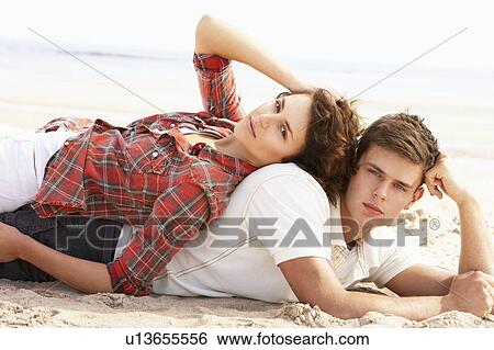 Stock Photograph - Romantic Young Couple Relaxing On Beach. Fotosearch
