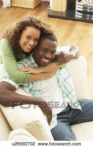 Stock Image - Romantic Young Couple Relaxing Sitting On Sofa. Fotosearch
