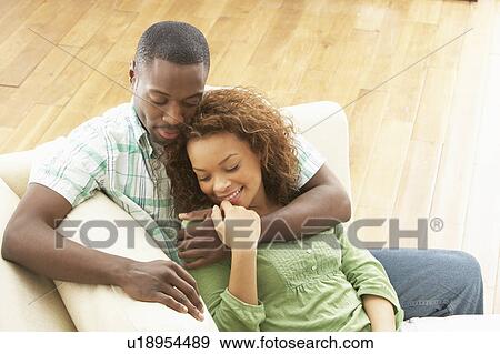 Stock Photo - Romantic Young Couple Relaxing Sitting On Sofa. Fotosearch