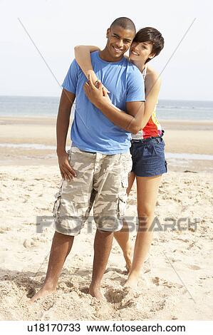 Stock Image - Romantic Young Couple Standing On Beach . Fotosearch