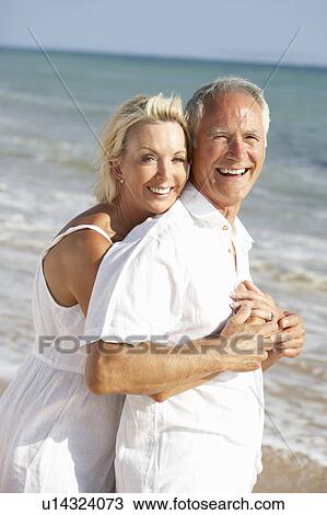 Stock Image - Senior Couple Enjoying Beach Holiday. Fotosearch