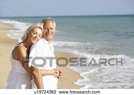 Stock Image - Senior Couple Enjoying Beach Holiday. Fotosearch