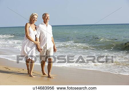 Stock Photograph - Senior Couple Enjoying Beach Holiday. Fotosearch