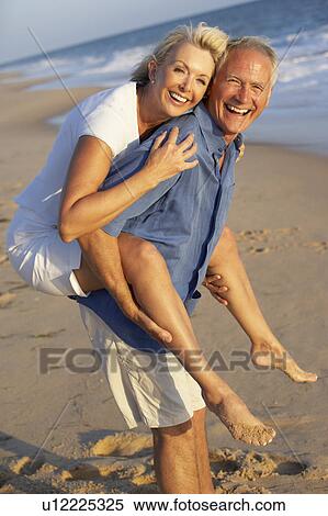 Stock Photography - Senior Couple Enjoying Beach Holiday. Fotosearch