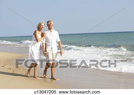 Stock Photography - Senior Couple Enjoying Beach Holiday. Fotosearch
