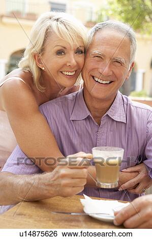 Stock Photograph - Senior Couple Enjoying Coffee And Cake In Café. Fotosearch