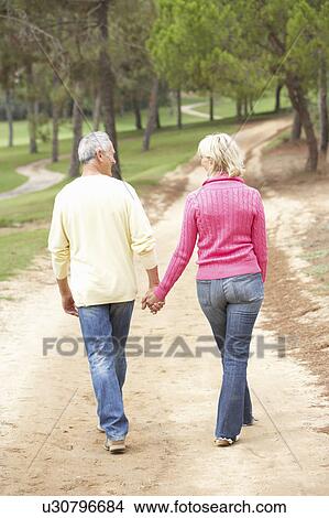 Senior Couple enjoying walk in park View Large Photo Image Picture - Senior Couple enjoying walk in park. Fotosearch