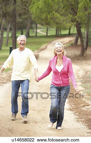 Senior Couple enjoying walk in park View Large Photo Image Stock Image - Senior Couple enjoying walk in park. Fotosearch