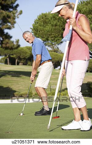 Senior Couple Golfing On Golf Course Lining Up Putt On Green View Large Photo Image Stock Image - Senior Couple Golfing On Golf Course Lining Up Putt On Green. Fotosearch