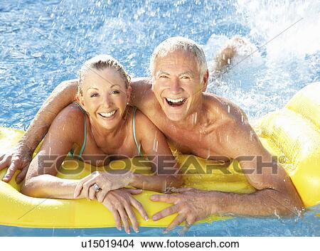 Picture - Senior couple having fun in pool. Fotosearch