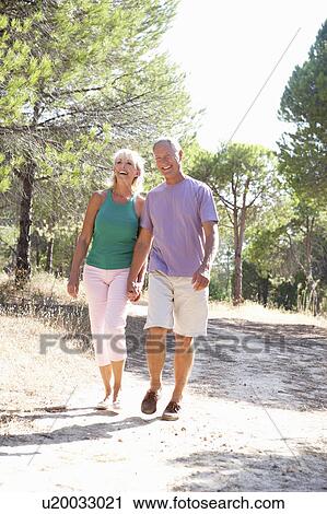 Senior couple, holding hands, walking, walk in park View Large Photo Image Stock Image - Senior couple, holding hands, walking, walk in park. Fotosearch
