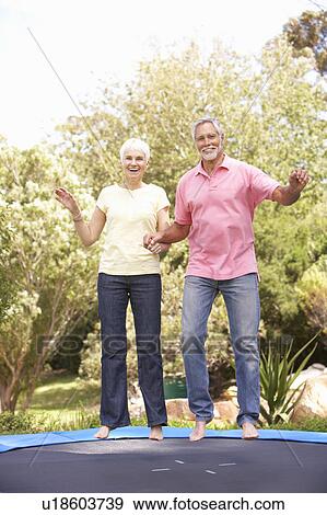 Senior Couple Jumping On Trampoline In Garden View Large Photo Image Stock Photo - Senior Couple Jumping On Trampoline In Garden. Fotosearch