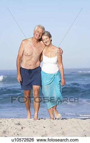 Senior Couple On Holiday Walking Along Sandy Beach View Large Photo Image Stock Photograph - Senior Couple On Holiday Walking Along Sandy Beach. Fotosearch