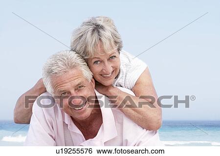 Stock Photograph - Senior Couple Relaxing On Beach Holiday. Fotosearch