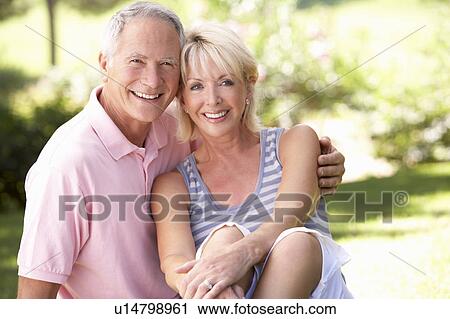 Stock Image - Senior couple relaxing together in park. Fotosearch