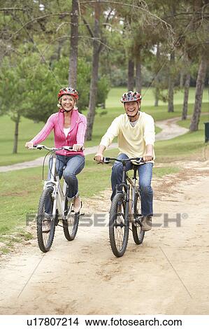 Senior couple riding bicycle in park View Large Photo Image Picture - Senior couple riding bicycle in park. Fotosearch