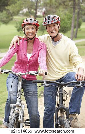 Senior couple riding bicycle in park View Large Photo Image Stock Photography - Senior couple riding bicycle in park. Fotosearch