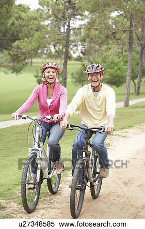 Senior couple riding bicycle in park View Large Photo Image Stock Photography - Senior couple riding bicycle in park. Fotosearch