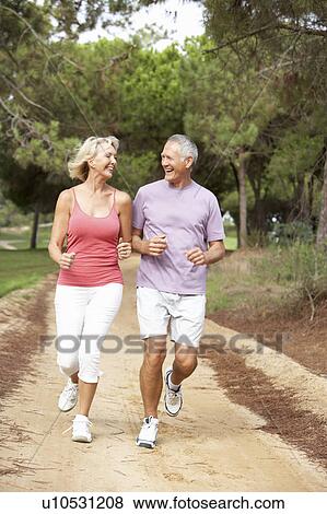 Stock Photo - Senior couple running in park. Fotosearch