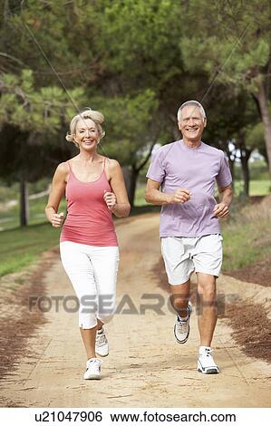 Stock Photograph - Senior couple running in park. Fotosearch
