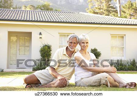 Stock Image - Senior Couple sitting Outside Dream Home. Fotosearch
