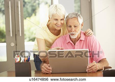 Stock Photograph - Senior Couple Using Laptop At Home. Fotosearch