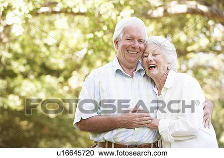 Stock Image - Senior Couple Walking In Park. Fotosearch