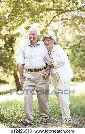 Stock Photo - Senior Couple Walking In Park. Fotosearch